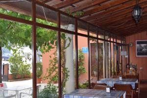 a patio with two tables and glass windows at Hotel Río Seco in Pedrera