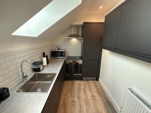 a kitchen with a sink and a counter top at Luxury 1 bed - 7 Queen Street Abingdon - Centrally located parking subject to availability in Abingdon