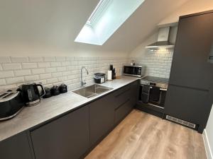 a kitchen with a sink and a counter top at Luxury 1 bed - 7 Queen Street Abingdon - Centrally located parking subject to availability in Abingdon