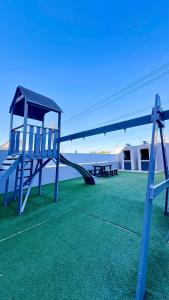 a playground with a slide on a green lawn at Sandton Nest in Johannesburg