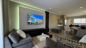 a living room with a couch and a tv at Sandton Nest in Johannesburg
