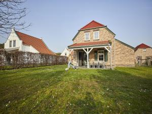 a person walking in a yard in front of a house at Farmhouse in Limburg with Sauna & Pool in Roggel