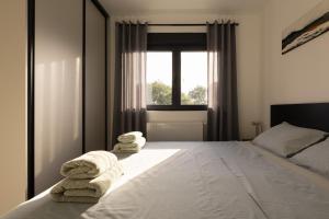 a bedroom with towels on a bed with a window at Holiday house Nova in Ližnjan