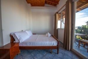a bedroom with a bed and a large window at Noemi's Hotel Ksamil in Ksamil