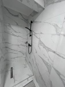 a bathroom with a shower with white marble walls at Apartman M&D in Neum