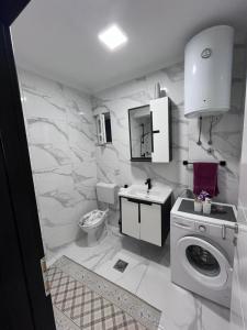 a white bathroom with a washing machine and a sink at Apartman M&D in Neum