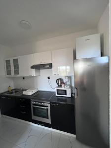 a kitchen with a stainless steel refrigerator and a microwave at Apartman M&D in Neum