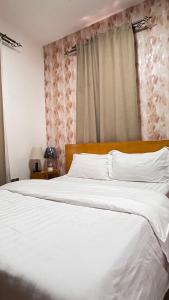 a large white bed in a bedroom with a window at Silver Homes Ug K05 in Kampala