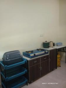 a kitchen with a counter with a stove and a table at AbeY Homestay in Gua Sai +2 photos
