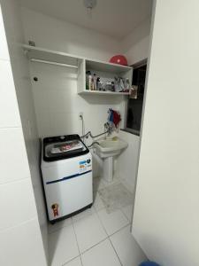 een kleine witte keuken met een fornuis en een wastafel bij Apartamento Pedreira in Belém