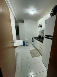 een keuken met witte apparatuur en een witte tegelvloer bij Apartamento Pedreira in Belém