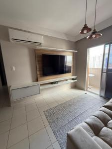 een woonkamer met een flatscreen-tv en een bank bij Apartamento Pedreira in Belém