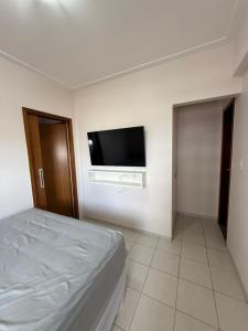 een slaapkamer met een bed en een flatscreen-tv bij Apartamento Pedreira in Belém +2 foto's