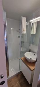 a white bathroom with a shower and a sink at Mobile home K in Biograd na Moru