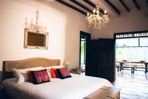 a bedroom with a bed with pillows and a chandelier at Finca Boutique el Diamante in Salgar +70 photos