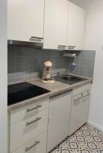 a kitchen with white cabinets and a sink at Schwarzwaldliebe in Schonwald im Schwarzwald +9 photos