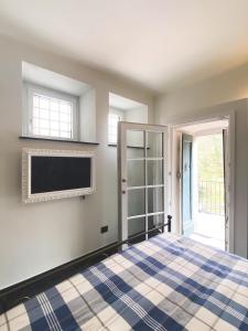 a bedroom with a bed and a tv on a wall at Residenza Nemus Vinea Mare e Montagna in Graveglia