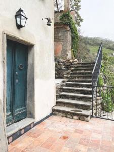 a stairway with a green door next to a building at Residenza Nemus Vinea Mare e Montagna in Graveglia