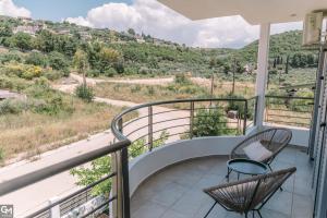 a balcony with two chairs and a view at GMhouse in Perdika