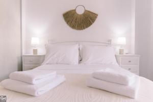 a white bedroom with white towels on a bed at GMhouse in Perdika