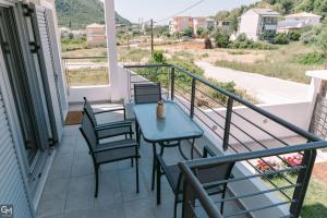 a patio with a table and chairs on a balcony at GMhouse in Perdika
