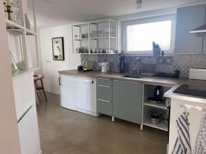 a kitchen with white cabinets and a sink and a window at Charmantes Häuschen am Waldrand in Neustadt an der Weinstraße