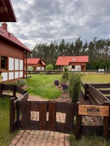 una recinzione in legno con giardino di fronte a una casa di Kaszubski Dom Ostoja Bukowo a Borowy Młyn