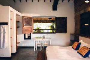 a room with a bed and a table and a window at Finca Boutique el Diamante in Salgar