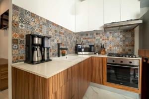 a kitchen with a sink and a coffee maker at Stylish Unit with Rooftop Pool, Walk to Beach and Malecon in Puerto Vallarta +15 photos
