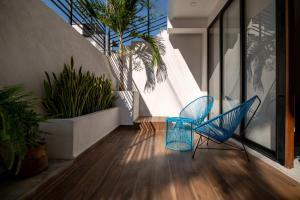 a room with two blue chairs and some plants at Stylish Unit with Rooftop Pool, Walk to Beach and Malecon in Puerto Vallarta