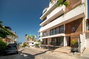 a building with a car parked in front of it at Stylish Unit with Rooftop Pool, Walk to Beach and Malecon in Puerto Vallarta