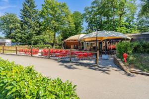 a group of tables and chairs with umbrellas at Mobil home paisible in Saint-Chéron