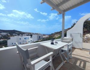 Ein weißer Tisch und Stühle auf einem Balkon mit Aussicht in der Unterkunft Koukida House in Donousa