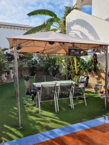 einen Tisch und Stühle unter einem großen Schirm in der Unterkunft Amanecer Costero in Orihuela + 2 Fotos