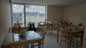 a restaurant with tables and chairs and a window at Malik Hotel Boutique in Cali