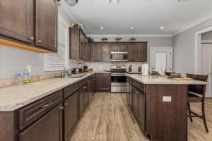 eine große Küche mit Holzschränken und Geräten aus Edelstahl in der Unterkunft Luxury 2 bedroom townhouse #4 in Lake Charles