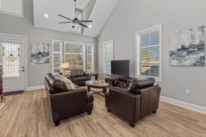 a living room with leather furniture and a flat screen tv at Luxury 2 Bedroom Townhouse #1 in Lake Charles