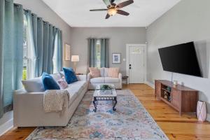 a living room with a couch and a flat screen tv at 1 Bedroom Home in Downtown Lake Charles La in Lake Charles +1 photo