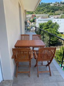 a wooden table and chairs on a balcony at Appartamento con terrazza fronte mare in Cogoleto