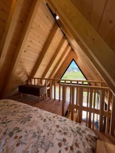 a bedroom with a bed in a wooden attic at Grlo Sokolovo A-Frame Cottage - Mountain Retreat near Podgorica in Korita