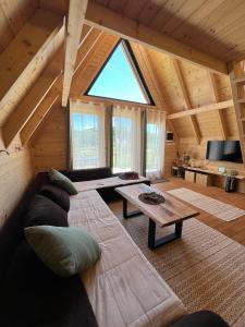a living room with a couch and a table at Grlo Sokolovo A-Frame Cottage - Mountain Retreat near Podgorica in Korita