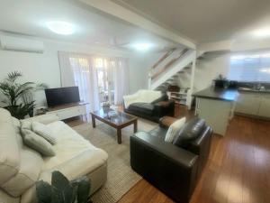 a living room with a couch and a table at Best location on the river in the beautiful Islander Resort in Noosaville