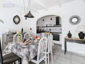 una cucina e una sala da pranzo con tavolo e sedie di Maison Ty Gwen - Centre-ville avec jardin et proche de la plage a Crozon Altre 48 foto