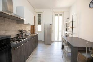 a kitchen with a refrigerator and a table in it at Relais Rosselli in Rome +43 photos