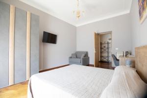 a bedroom with a white bed and a chair at Relais Rosselli in Rome