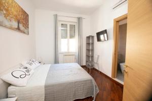 a white bedroom with a bed and a window at Relais Rosselli in Rome