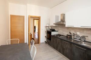 a kitchen with a black counter top and a table at Relais Rosselli in Rome
