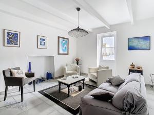 un soggiorno con un divano, sedie e un tavolo di Maison Ty Gwen - Centre-ville avec jardin et proche de la plage a Crozon
