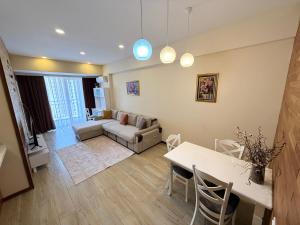 a living room with a couch and a table at Park Azure 0414 in Baku