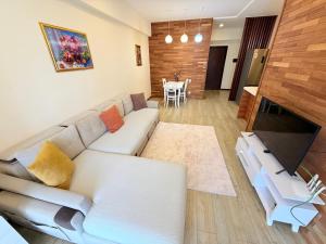 a living room with a white couch and a television at Park Azure 0414 in Baku